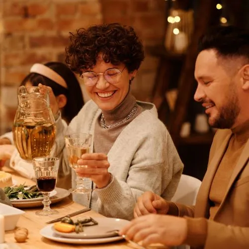 Family enjoying Christmas Meal together pouring drinks